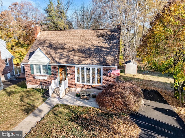 view of front of house featuring a patio and a shed