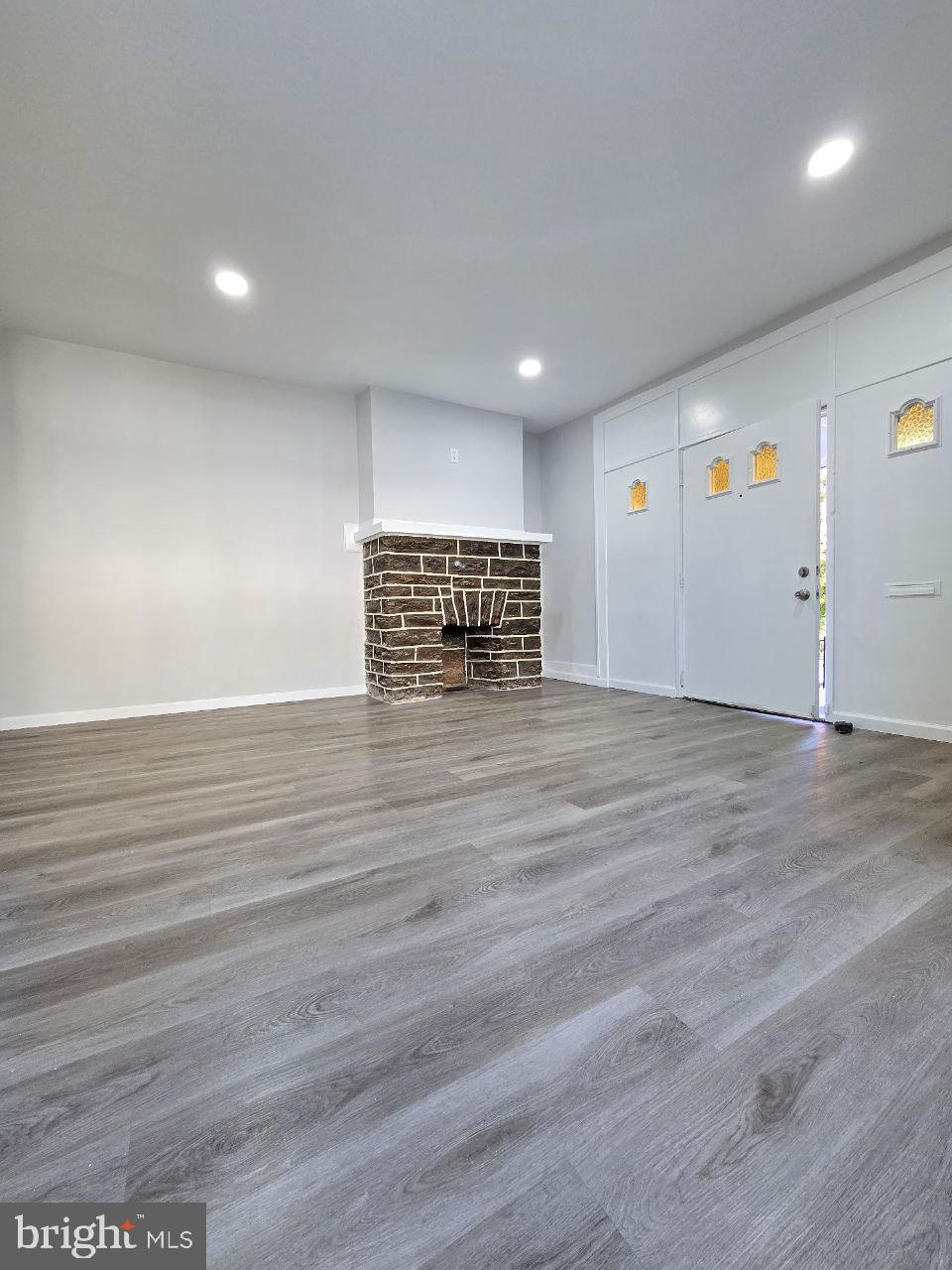 unfurnished living room with hardwood / wood-style flooring and a fireplace