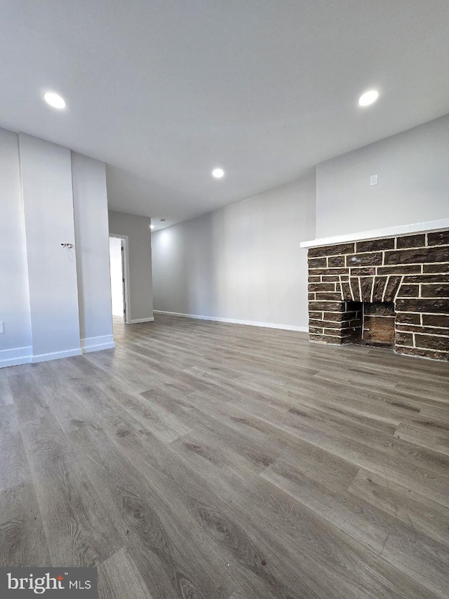 unfurnished living room featuring a fireplace and hardwood / wood-style flooring