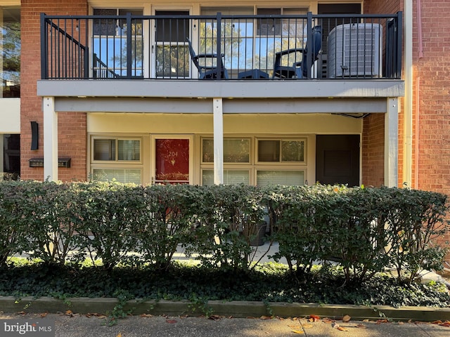 view of exterior entry featuring a balcony