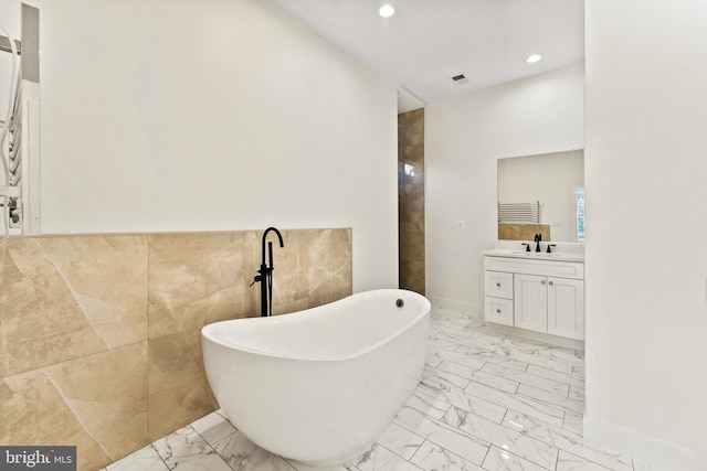 bathroom featuring vanity, tile walls, and a bathtub