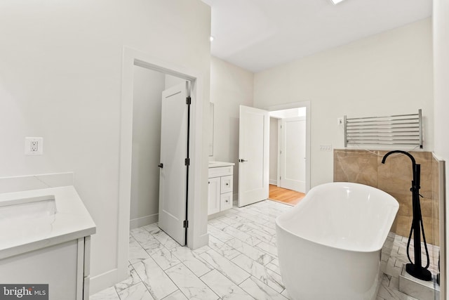 bathroom with vanity, a bathtub, and radiator heating unit