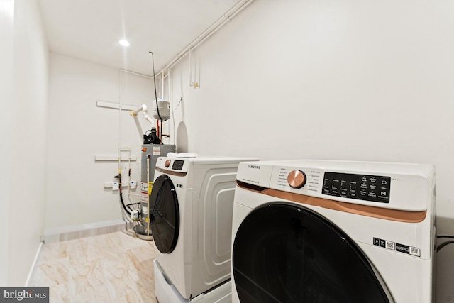 clothes washing area featuring washer and clothes dryer and water heater