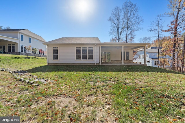 back of house with a patio and a lawn