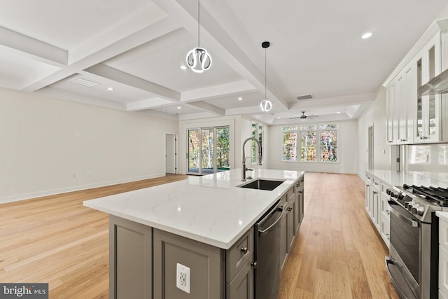 kitchen with white cabinetry, an island with sink, sink, hanging light fixtures, and stainless steel appliances