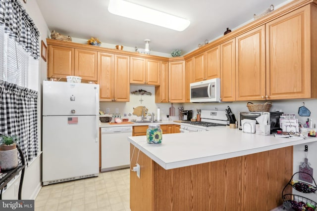 kitchen featuring light brown cabinets, sink, white appliances, and kitchen peninsula