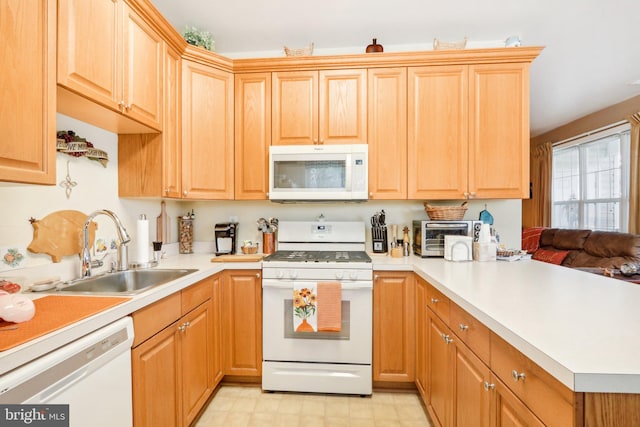 kitchen featuring kitchen peninsula, sink, and white appliances