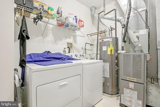 laundry room featuring washing machine and dryer, heating unit, and gas water heater