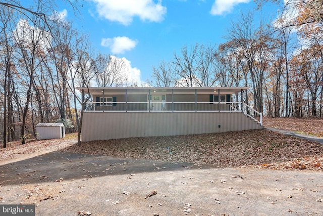 back of house with a storage unit