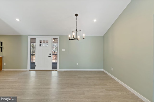 unfurnished dining area with a chandelier and light wood-type flooring