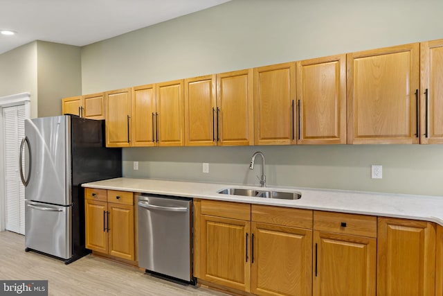 kitchen with sink, appliances with stainless steel finishes, and light hardwood / wood-style floors