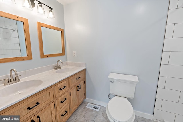 bathroom featuring tile patterned flooring, vanity, and toilet