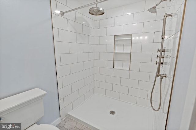 bathroom featuring toilet and tiled shower