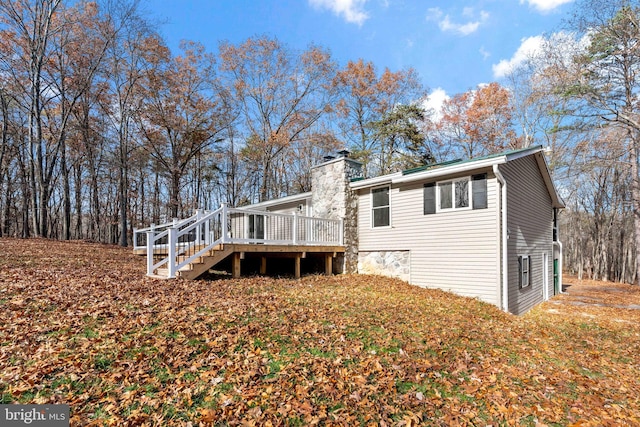 rear view of property featuring a wooden deck