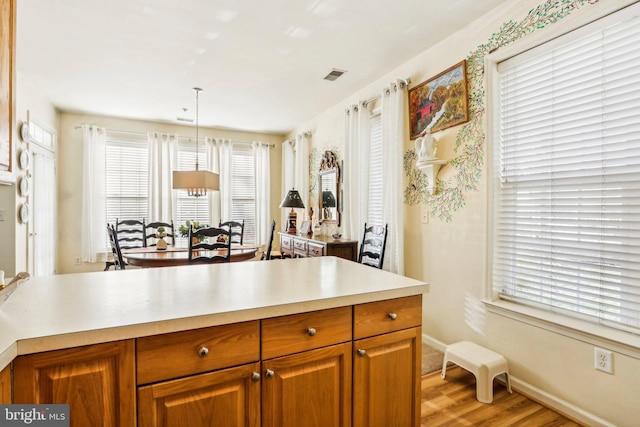 kitchen featuring decorative light fixtures and light hardwood / wood-style flooring