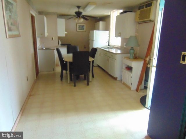 dining area with ceiling fan, sink, and a wall unit AC