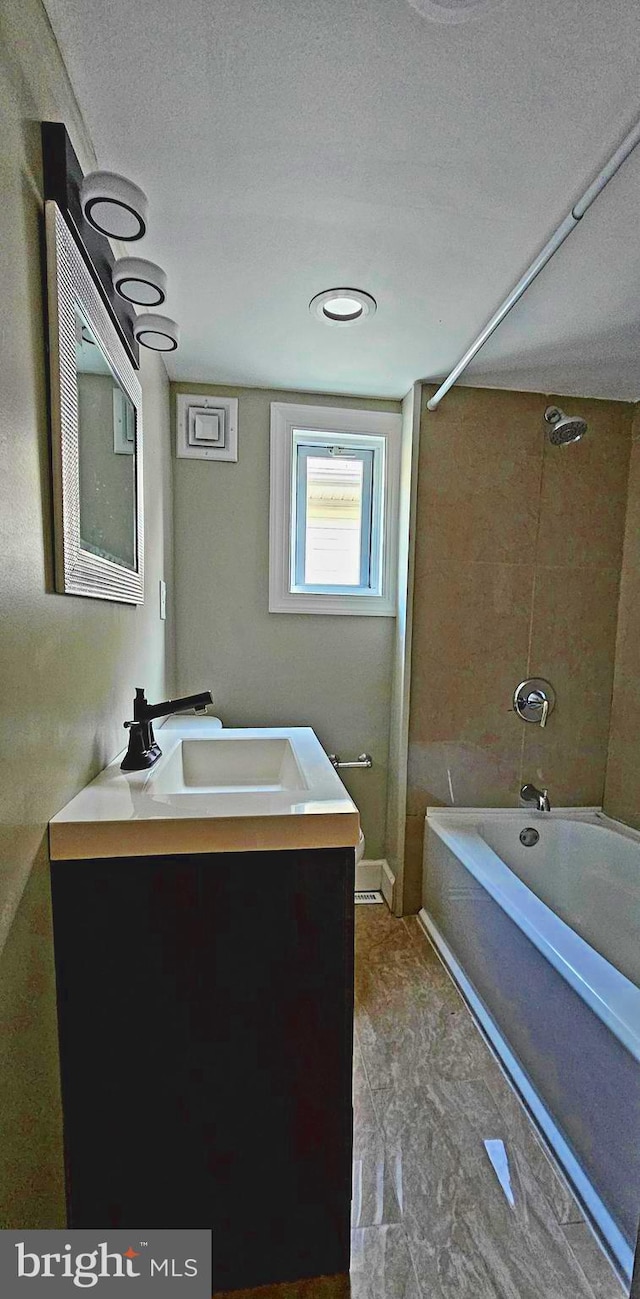 bathroom with vanity, a textured ceiling, and bathing tub / shower combination