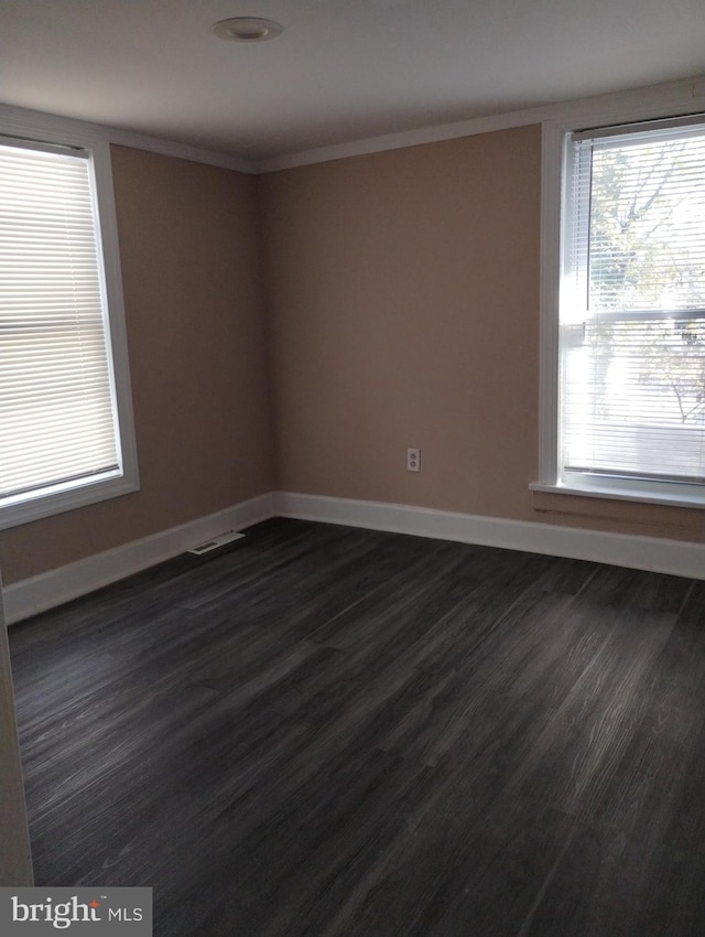 spare room featuring dark hardwood / wood-style flooring and ornamental molding