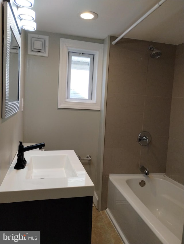 bathroom featuring tile patterned floors, vanity, and tiled shower / bath