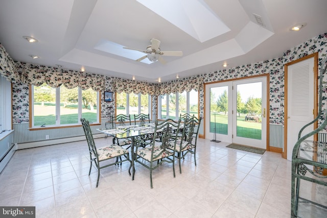 dining space with a wealth of natural light, ceiling fan, light tile patterned floors, and a skylight