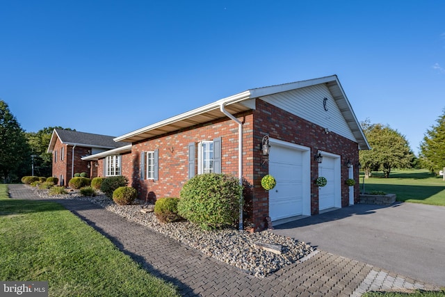 view of property exterior featuring a garage and a lawn