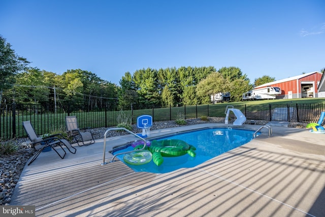 view of swimming pool with a water slide and a patio area