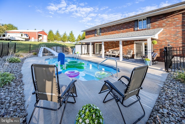 view of pool with a hot tub, a patio area, and a water slide