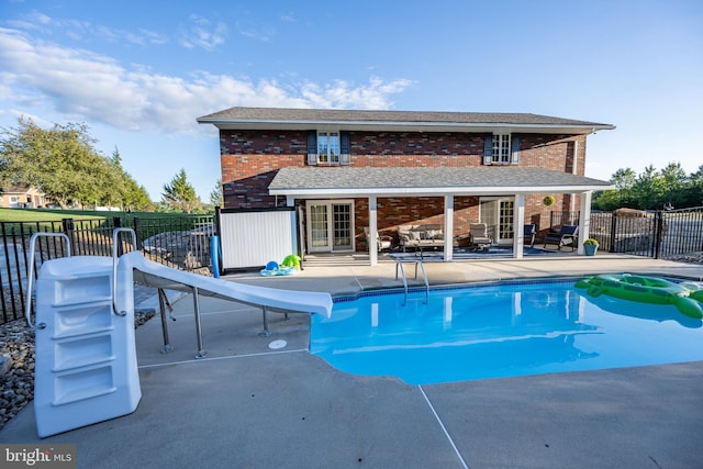 view of swimming pool with a patio and a water slide