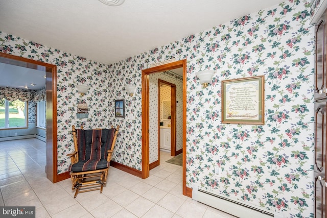 sitting room featuring light tile patterned flooring, baseboard heating, and a textured ceiling