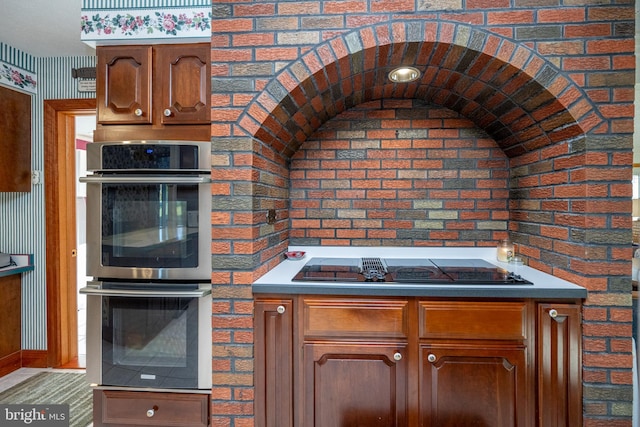 kitchen with gas cooktop, double oven, and brick wall