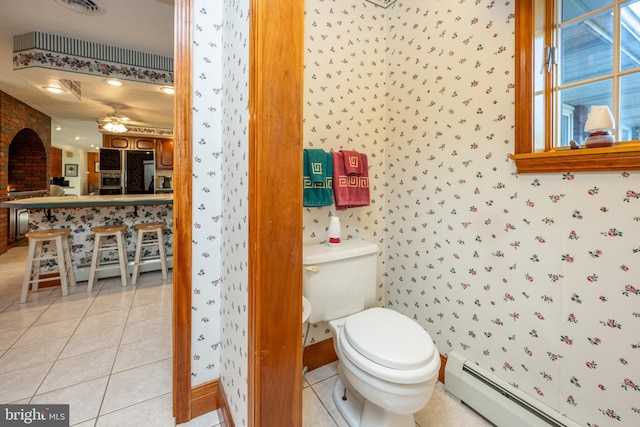 bathroom featuring ceiling fan, tile patterned flooring, toilet, and a baseboard heating unit