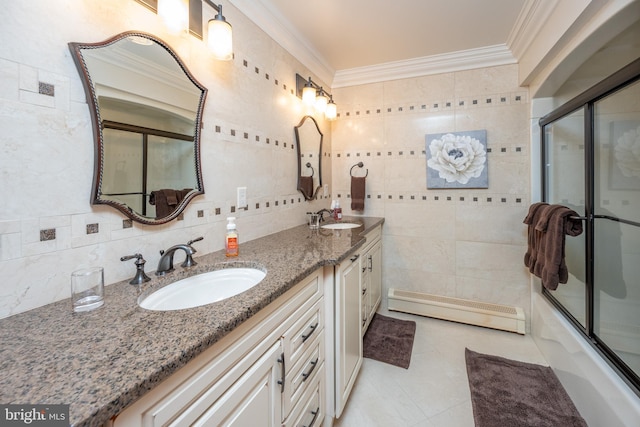 bathroom with tile walls, ornamental molding, vanity, bath / shower combo with glass door, and a baseboard radiator