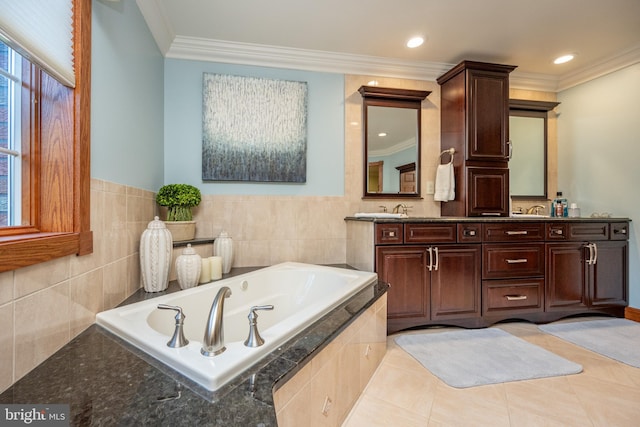 bathroom with tile patterned flooring, a relaxing tiled tub, vanity, crown molding, and tile walls