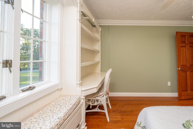 bedroom featuring ornamental molding, hardwood / wood-style floors, and a textured ceiling