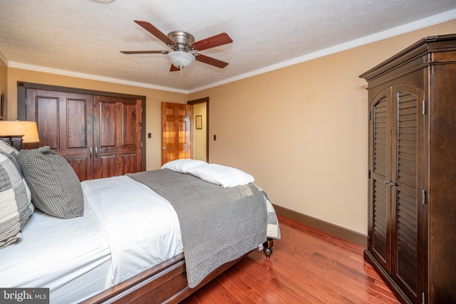 bedroom with ornamental molding, a textured ceiling, hardwood / wood-style flooring, and ceiling fan