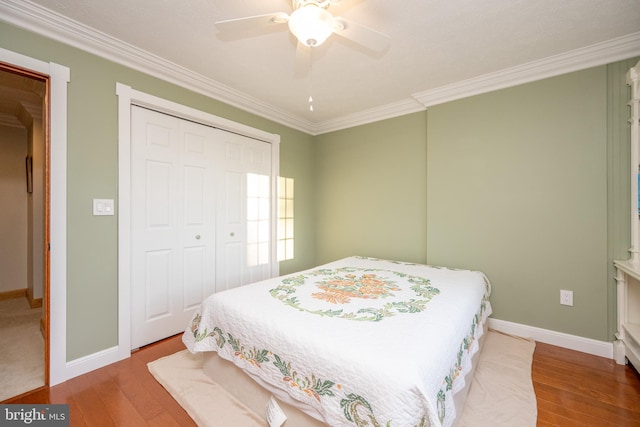 bedroom featuring hardwood / wood-style floors, ceiling fan, a closet, and crown molding