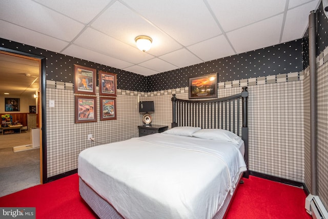 bedroom featuring a paneled ceiling, baseboard heating, and carpet floors