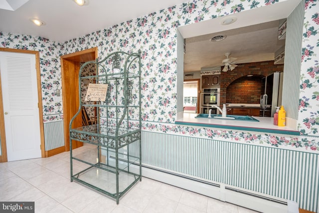 bathroom with tile patterned floors, sink, baseboard heating, and ceiling fan