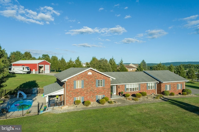 ranch-style house featuring a front yard and a fenced in pool