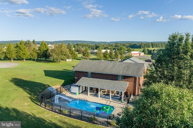 view of swimming pool featuring a patio, a lawn, and a storage unit