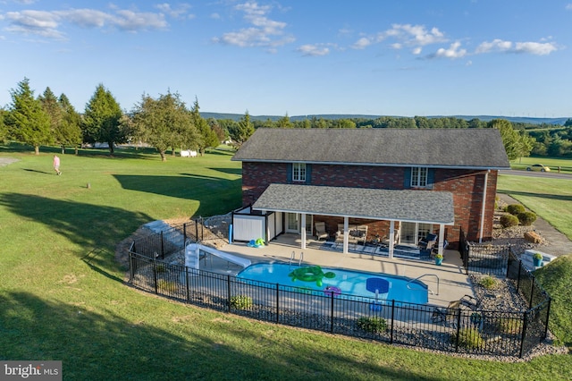 view of pool with an outbuilding, a patio area, and a lawn