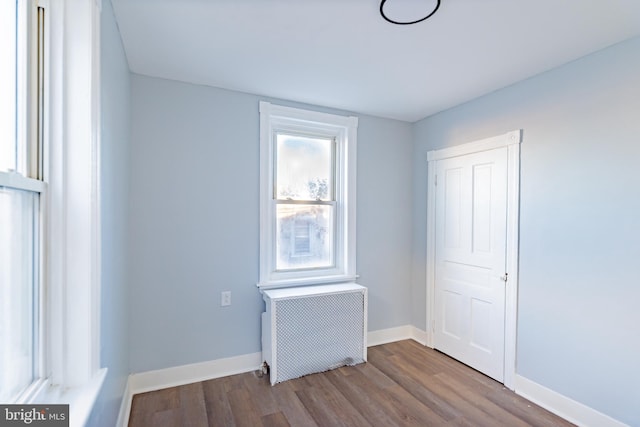 unfurnished room featuring radiator heating unit and light hardwood / wood-style flooring