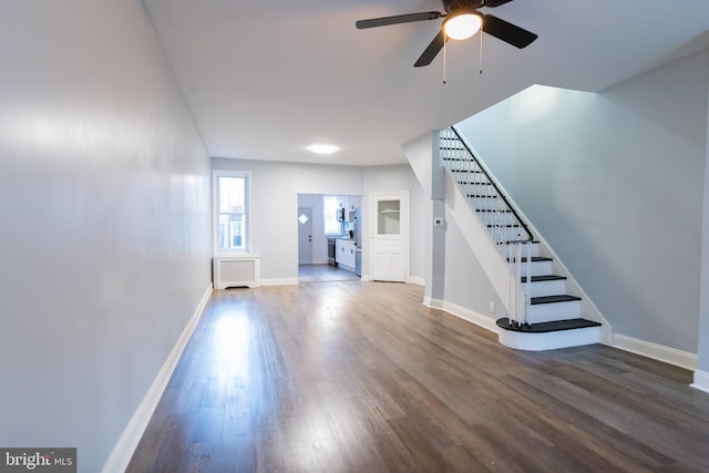 unfurnished living room featuring radiator heating unit, dark wood-type flooring, and ceiling fan