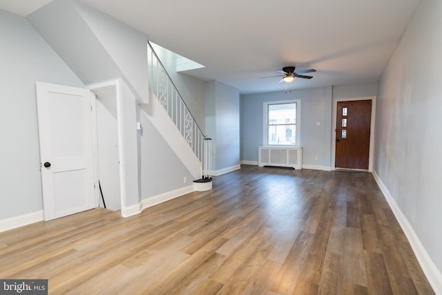 foyer featuring wood-type flooring, ceiling fan, and radiator