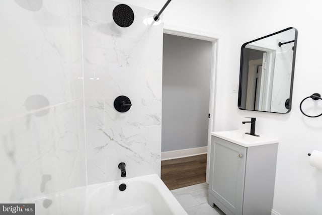 bathroom with vanity, tiled shower / bath, and wood-type flooring