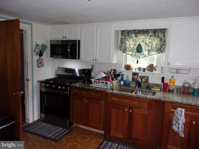 kitchen with white cabinetry, appliances with stainless steel finishes, and light stone counters