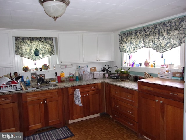 kitchen featuring sink and light stone counters