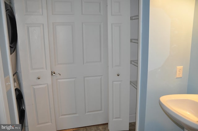 bathroom with stacked washer / dryer and sink