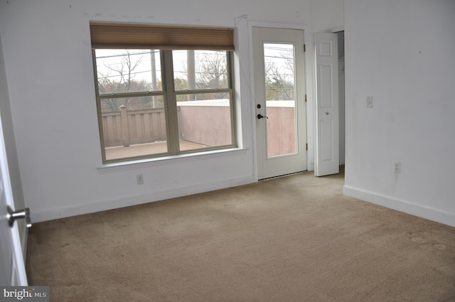 spare room featuring light carpet