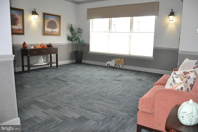 sitting room with dark carpet and ornamental molding